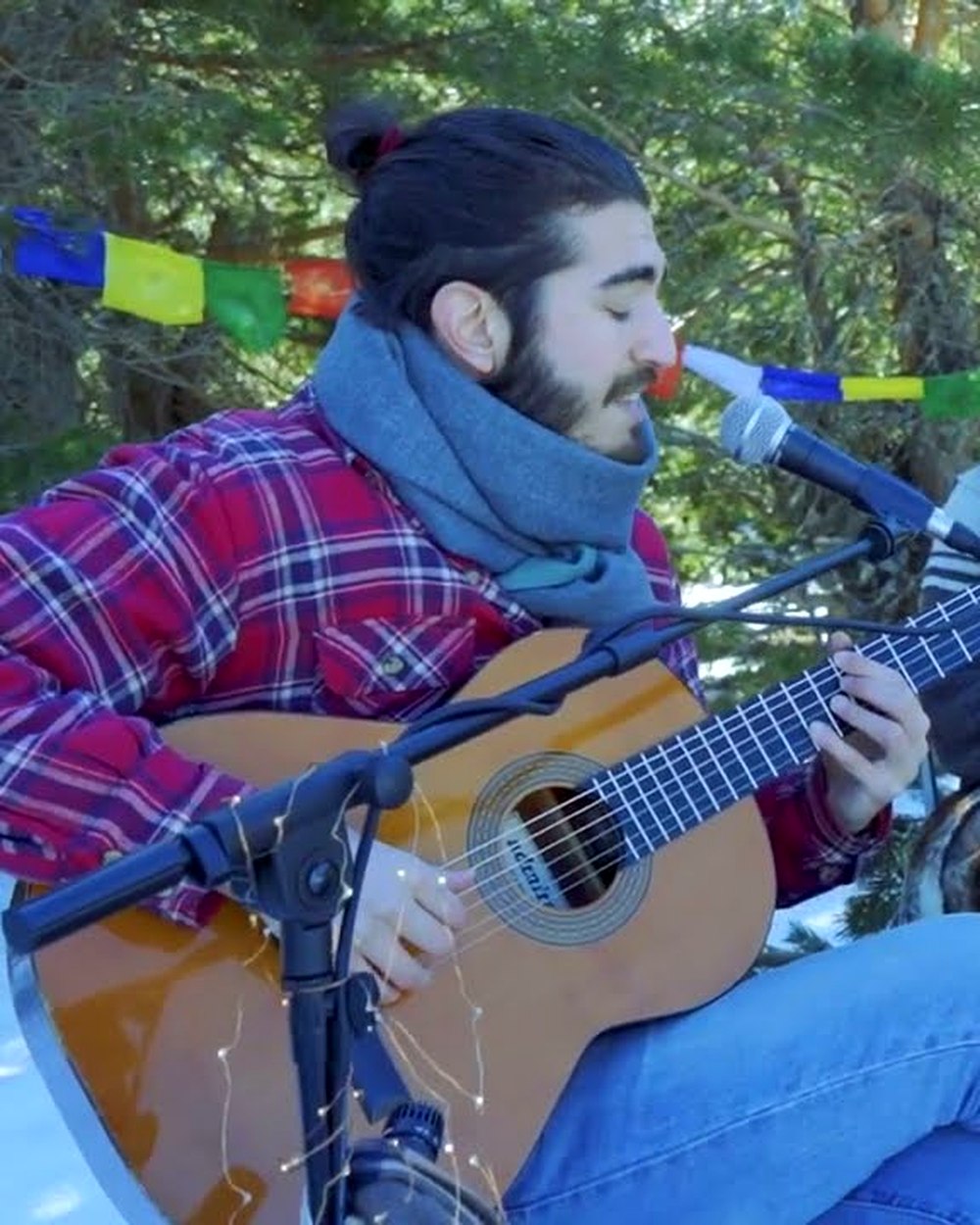 Alfonso Bucero tocando la guitarra en la nieve